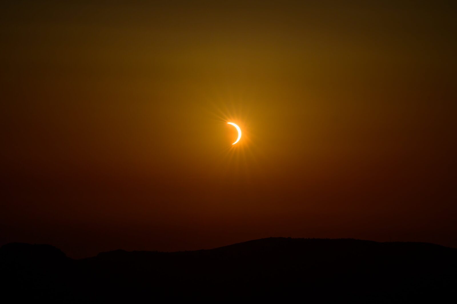 Éclipse solaire d'août 2026 au-dessus d'une ligne de crêtes