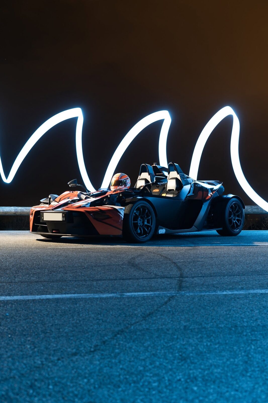 Light painting en arcs lumineux derrière une voiture de sport